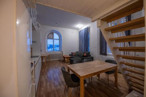 a living room with a table and chairs and a staircase at Abisko Guesthouse & Activities in Abisko
