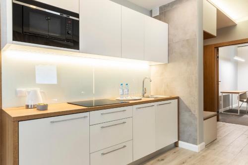 a kitchen with white cabinets and a sink at Royal Hill Residence in Zakopane