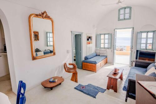 a living room with a mirror and a couch at Zoe Aegeas Traditional houses in Oia