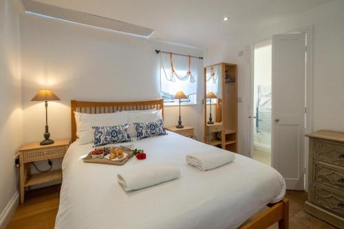 a bedroom with a large white bed with a tray of food on it at 9 Uplands in Thorpeness