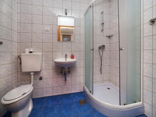 a bathroom with a toilet and a sink and a shower at Apartments Barbara in Brseč