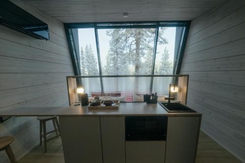 a kitchen with a table and a large window at Salla Wilderness Lodges in Salla