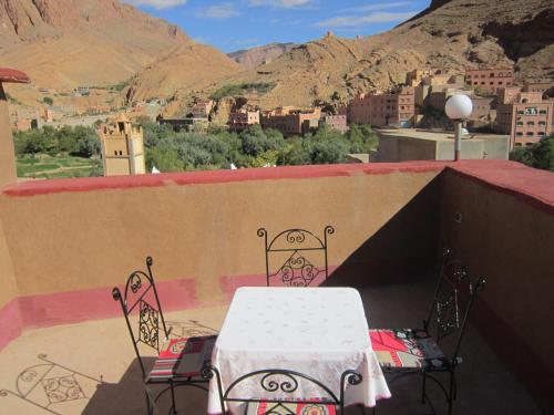 a table and chairs on a balcony with a view at Kasbah Maison D’hôte Lalla Zahra in Aït Baha