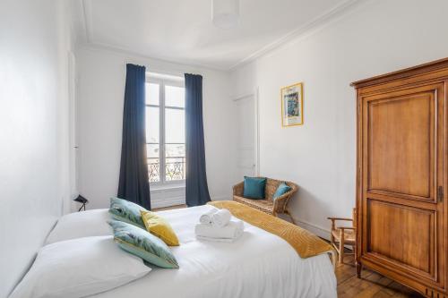 une chambre avec deux lits blancs et une fenêtre dans l'établissement Le Saint-Clément - Quartier Historique- Spacieux 2 chambres rue du Marechal Joffre, à Nantes