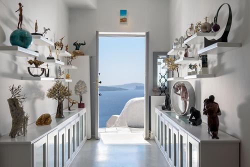 a room with white shelves and a door with a window at Oia Treasures Art Suites in Oia