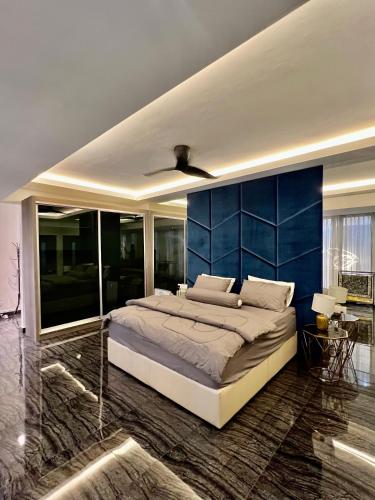 a bedroom with a large bed with a blue wall at Bangi Evo Luxury Suite in Bandar Baru Bangi