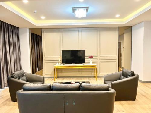 a living room with two couches and a flat screen tv at S.R.SUNSHINE HOTEL in Ban Sok Dua