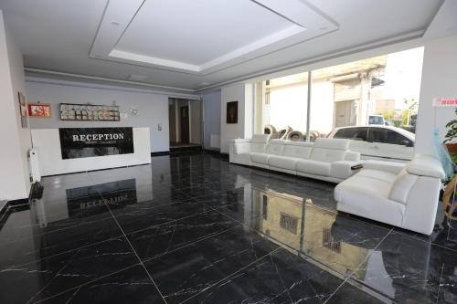eine Lobby mit weißen Möbeln und einem Kamin in der Unterkunft Kommageneiz hotel in Adıyaman