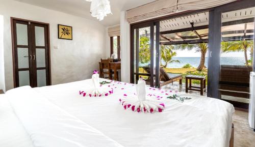 een slaapkamer met een wit bed met bloemen erop bij Lazy Day The Resort in Ko Mak