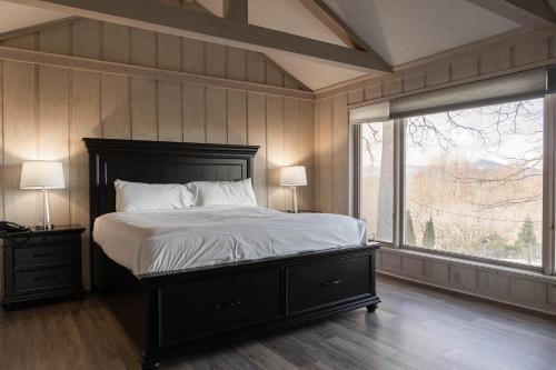 - une chambre avec un grand lit et une grande fenêtre dans l'établissement Inn at Crestwood, à Boone