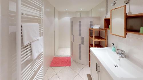 uma casa de banho branca com um lavatório e um chuveiro em Frühstücks-Radpension Taurer-Thoman em Dellach im Drautal