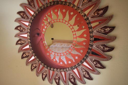 a mirror hanging on a wall with a red at Il Girasole in SantʼAntìoco