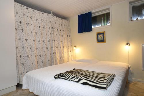 Cottage with sea view near Marstrand في Lycke: غرفة نوم مع سرير مع بطانية للحمار الوحشي عليها