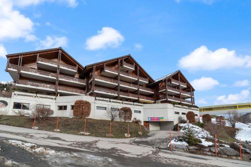a building with balconies on the side of it at Charmant studio rénové situé dans les bains d'Ovronnaz, immeuble les Sources in Ovronnaz