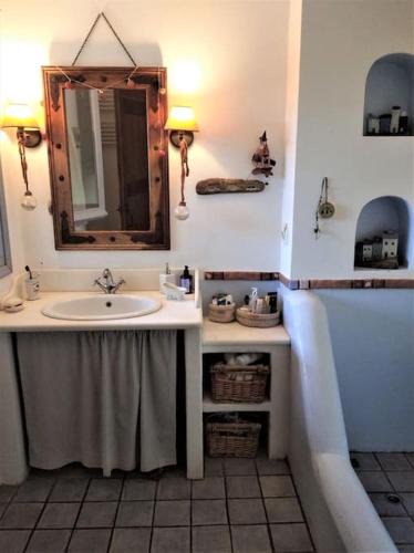 a bathroom with a sink and a mirror and a tub at C & C _ Cycladic house with endless sea view in Ermoupoli