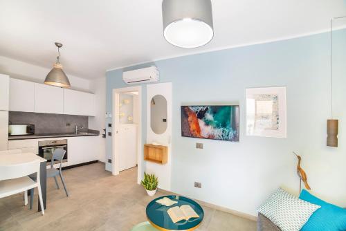 a living room with a table and a kitchen at Casa sulle Mura in Loano