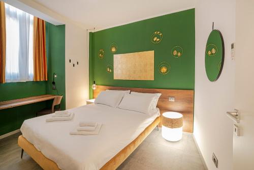 a bedroom with a large bed with a green wall at Casa sulle Mura in Loano
