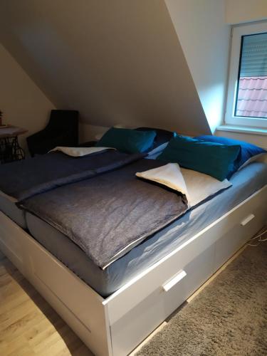 a bed with blue and white pillows on it at Gästehaus Hölting in Lübberstedt