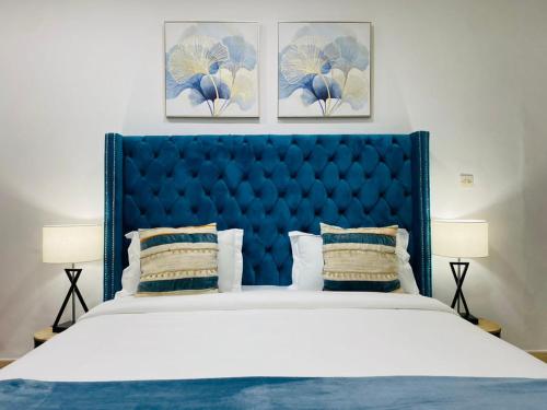 a large bed with a blue headboard in a bedroom at ILLIYIN Boutique Hotel in Dakar