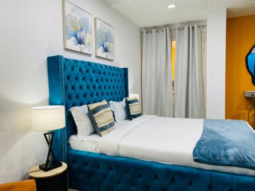 a blue bed with a blue headboard in a room at ILLIYIN Boutique Hotel in Dakar