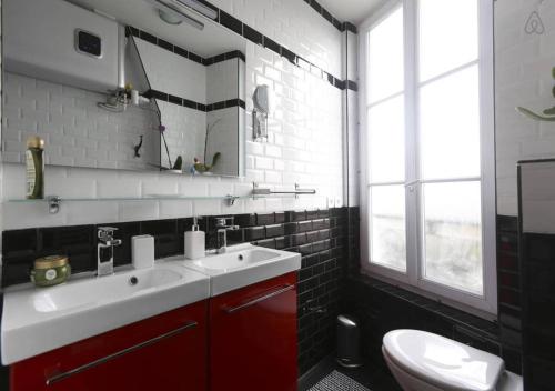 La salle de bains est pourvue d'un lavabo blanc et de toilettes. dans l'établissement Mairie de Saint-Ouen (Métro 13/14), à Saint-Ouen