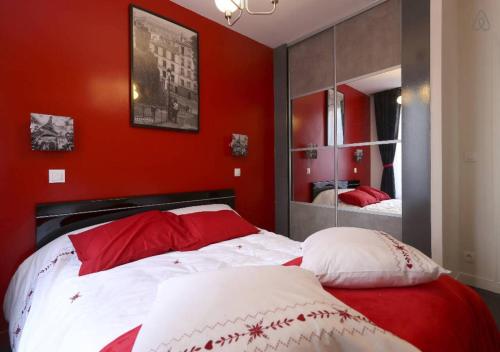 Dormitorio rojo con cama y espejo en Mairie de Saint-Ouen (Métro 13/14), en Saint-Ouen