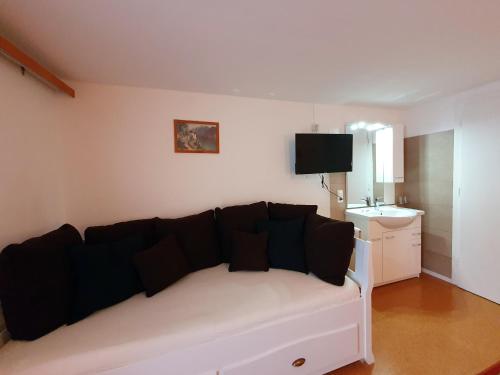 a white couch with black pillows in a living room at Bergkristall Apartments in Ischgl