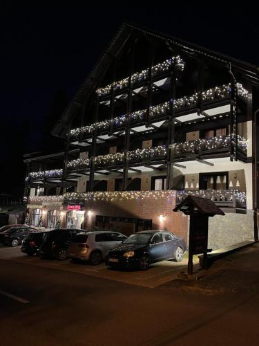 a building with cars parked in a parking lot at night at Casa Iris-Hotel & Restaurant in Sinaia