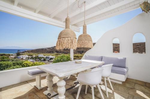 a dining room with a table and a view of the ocean at VLIA MAR Myconian Residences in Kalafatis