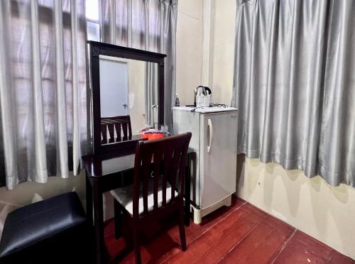 eine Küche mit einem weißen Kühlschrank sowie einem Tisch und Stühlen in der Unterkunft MrT Riverside Sampran มิสเตอร์ที โฮมสเตย์-การเวก in Sam Phran