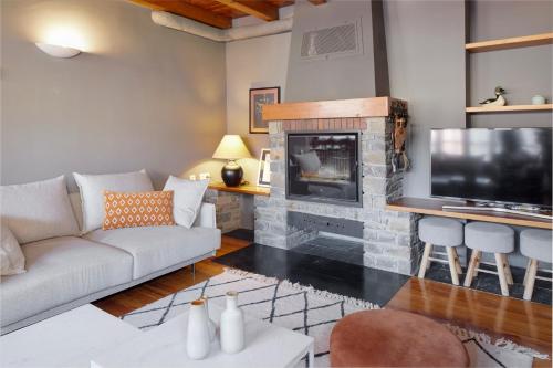 sala de estar con sofá y chimenea en El Jardí Secret by FeelFree Rentals en Escuñau