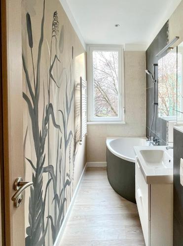 a bathroom with a bath tub and a sink at Millennium Apartman Tatabánya in Tatabánya