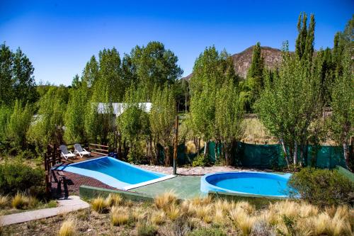 une image de deux piscines dans une cour dans l'établissement Cabañas Premium Mirador Azul, à Potrerillos