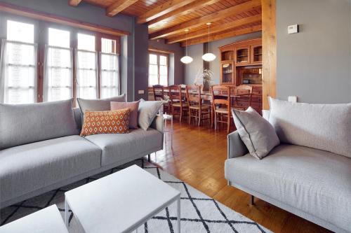a living room with two couches and a dining room at El Jardí Secret by FeelFree Rentals in Escuñau