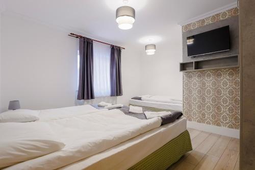 a bedroom with two beds and a flat screen tv at VAiAs Aparts in Tîrgu Neamţ