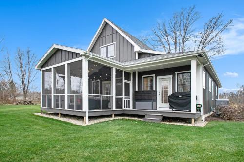 a house with a screened in porch on a lawn at Hidden Serenity in Sawyer
