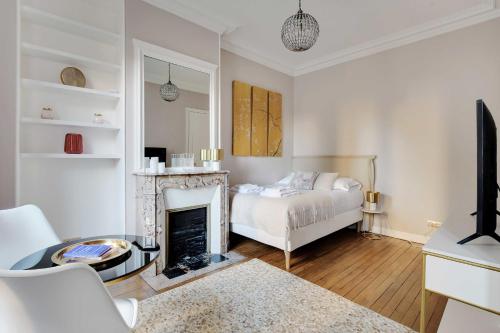 ein Wohnzimmer mit einem Bett und einem Kamin in der Unterkunft Charming Studio - 2P Villiers in Paris