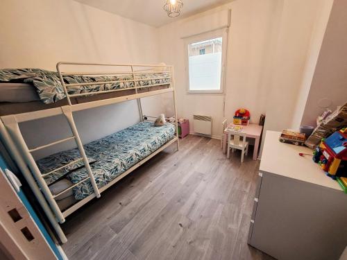 a bedroom with two bunk beds and a desk at De la détente dans ce coin de campagne. in Équemauville