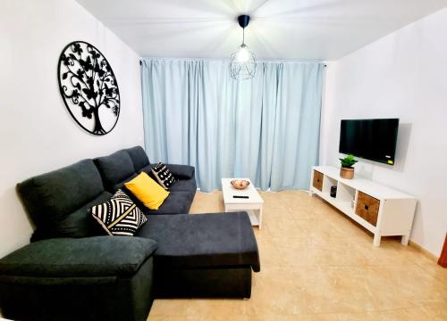 sala de estar con sofá y TV en Las Inglesitas, en Los Llanos de Aridane