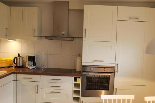 a kitchen with white cabinets and an oven at Haus-Anker in Wittdün