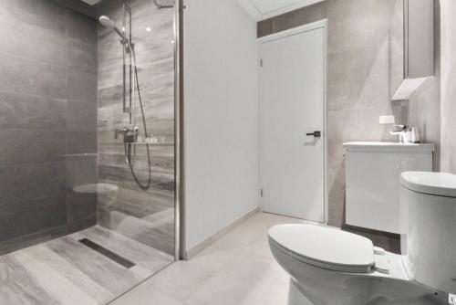 a bathroom with a toilet and a glass shower at Bocobay Gold Coast Resort in Palm-Eagle Beach