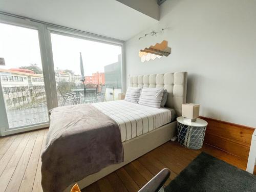 a bedroom with a bed and a large window at NiP Apartment | Porto City Center Near All Sights in Porto