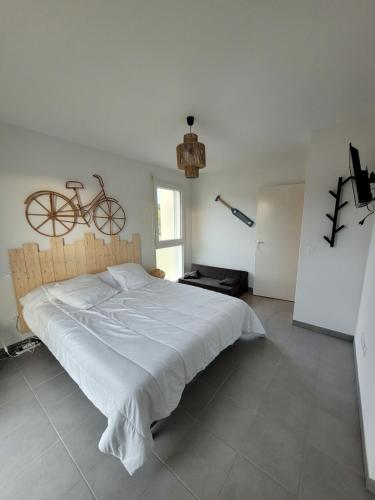 - une chambre avec un lit et un vélo sur le mur dans l'établissement Douceur Atlantique, à Mimizan