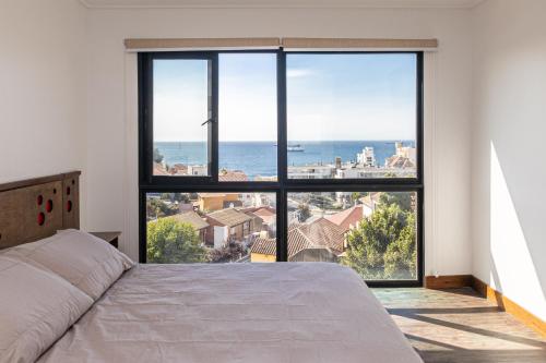 a bedroom with a large window overlooking the ocean at Hotel Ossido Nero in Viña del Mar