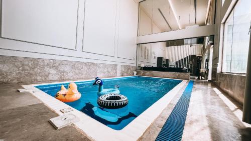 a swimming pool with two ducks in the middle of a building at شاليه رويال الخبر - Royal Resort AL Khobar in Al Khobar