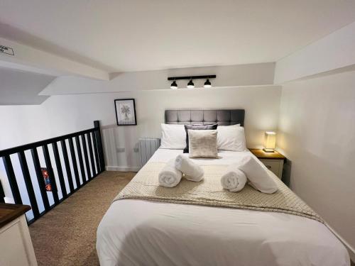 a bedroom with a large white bed with towels on it at Apartment 6 Sullivan House in Hereford