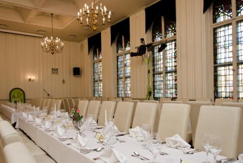 a long table in a room with white tables and chairs at Schwarzer Bär Jena in Jena
