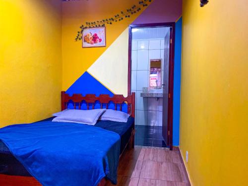 a bedroom with two beds and a yellow wall at Recanto Taquari - Praia e cachoeira in Paraty