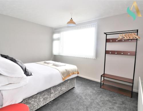 a white bedroom with a bed and a window at Newbury Lodge TSAC in Billingham