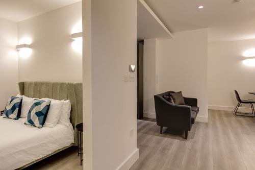 a living room with a bed and a chair at Charles Hope London Brentford in Brentford